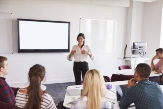 A teacher delivers a presentation to engaged students in a classroom, highlighting modern vet training.